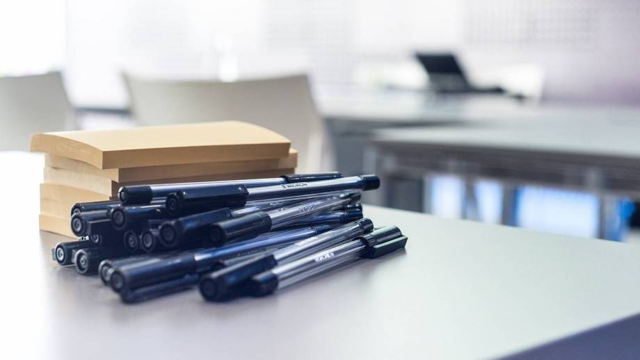 Pennen en notitieblokjes op een bureau.