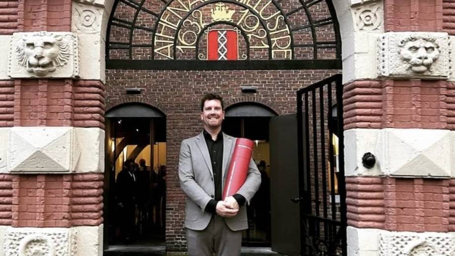 Roel Kooijmans met zijn ere-doctoraat van de Universiteit van Amsterdam.