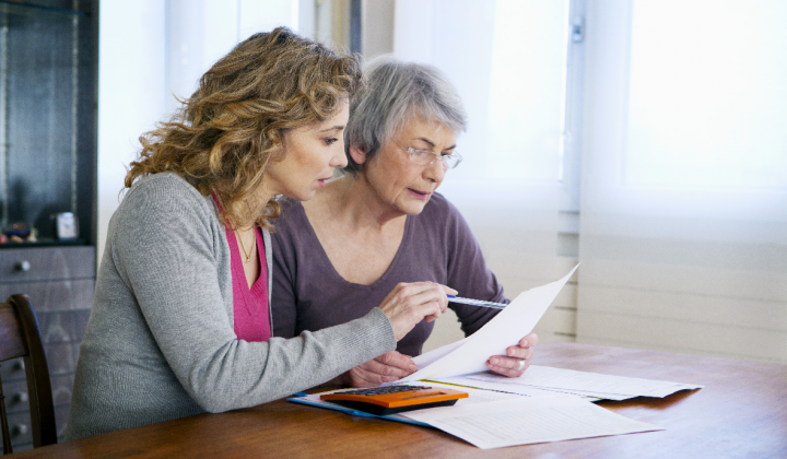 Twee vrouwen lezen een brief met pen in de hand.