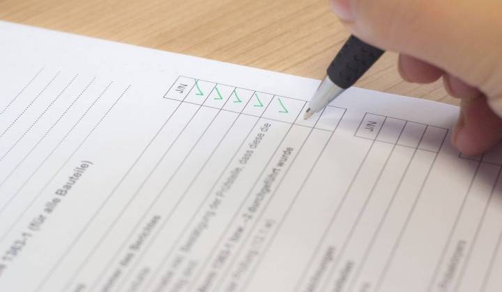 Iemand vult met pen een vragenlijst in.